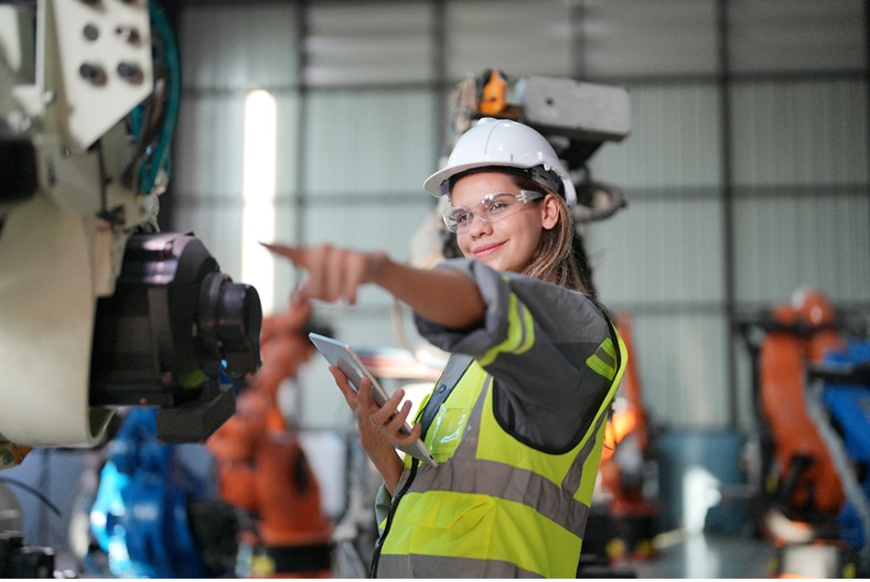 Robotic Arm engineer check on equipment in its with software of an Artificial Intelligence, Programming development technology work.
Female industrial engineer working at automated AI robotic production factory.